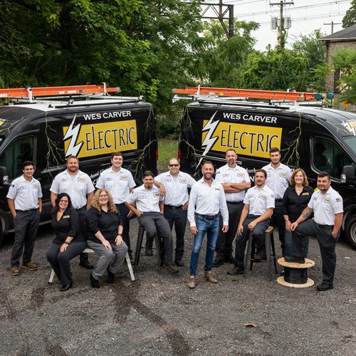 electrical technicians with work trucks on the background